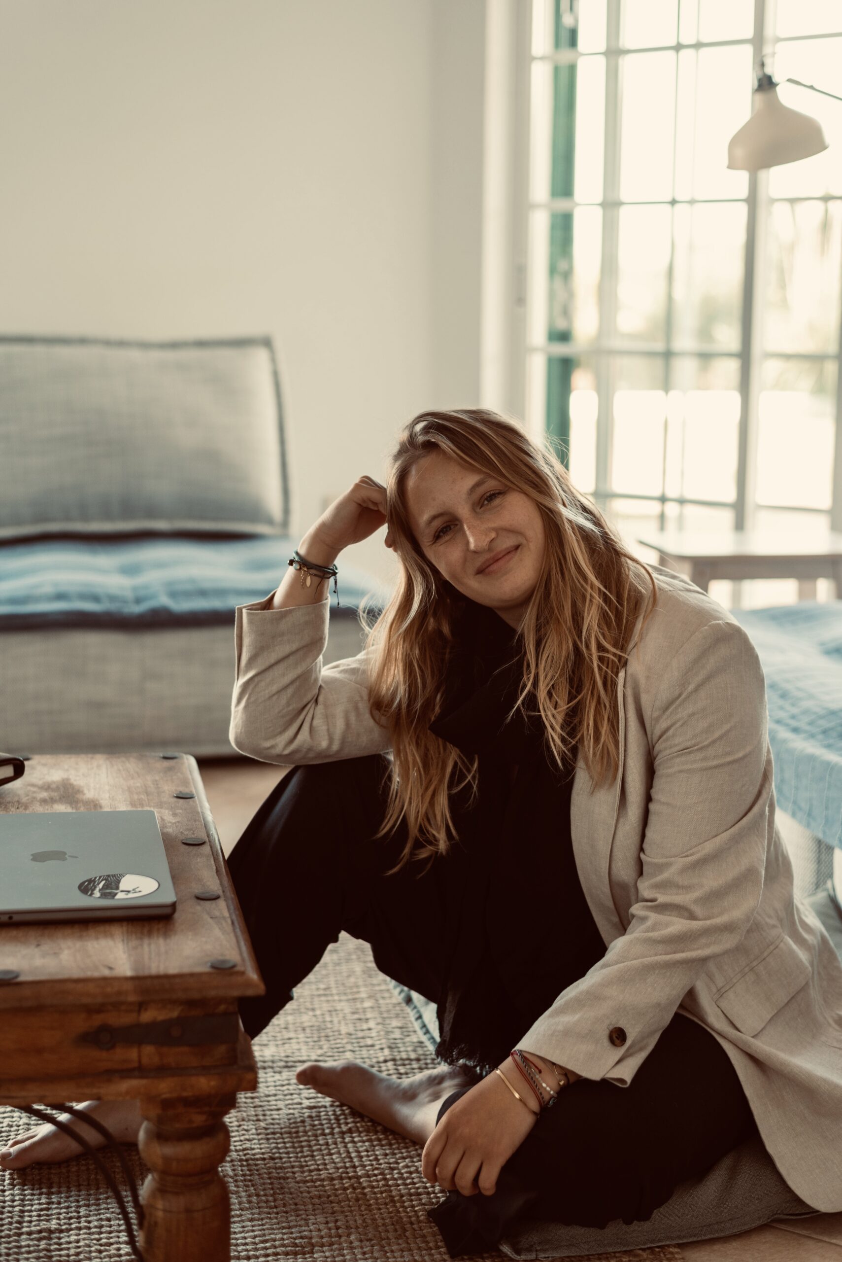 Katharina Ender, Mentorin und Expertin für Personal Brands am Boden sitzend in einem hellen Blazer vor ihrem Laptop