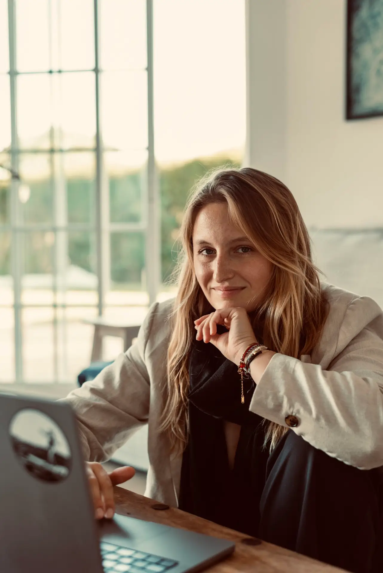 Katharina Ender als Expertin für LinkedIn Personal Branding am Laptop in einem beigen Blazer mit Blick in die Kamera